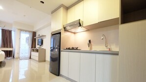 A modern kitchen with a built-in oven, a refrigerator, and a sink with a faucet. - Modern Studio The H Residence near MT Haryono (Jakarta)
