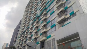 A high-rise building with multiple balconies and a sign indicating it is a hotel.