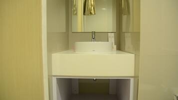 Un baño con un lavabo blanco, un espejo y una toalla colgada en la pared.