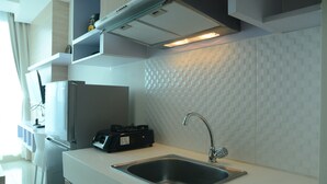 Een moderne keuken met een roestvrijstalen spoelbak, een inbouwfornuis en een magnetron.