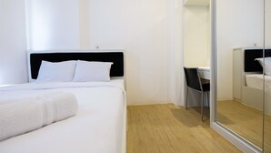 A hotel room with a bed, a desk, and a chair. - Spacious 2BR Apartment Connected to Bassura City Mall (Jakarta)