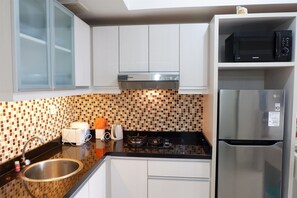 Habitación | Cocina privada | Refrigerador, microondas, parrilla de estufa y tetera eléctrica 