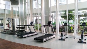 A gym with treadmills, dumbbells, and exercise bikes.