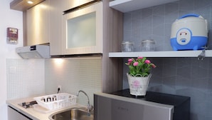 A modern kitchen with a stainless steel sink, a built-in dishwasher, and a white countertop.