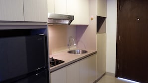 Una cocina moderna con refrigerador empotrado, pileta de acero inoxidable y extractor de aire.