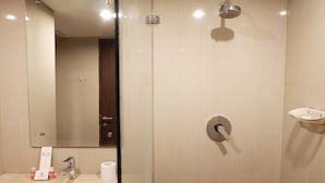 Un baño moderno con un espejo grande, un lavabo y una ducha.