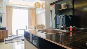 Una cocina moderna con una isla grande, electrodomésticos de acero inoxidable y vistas al área de estar.