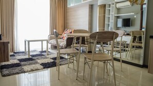 Una sala de estar moderna con comedor, que incluye un sofá, una mesa de centro y sillas.