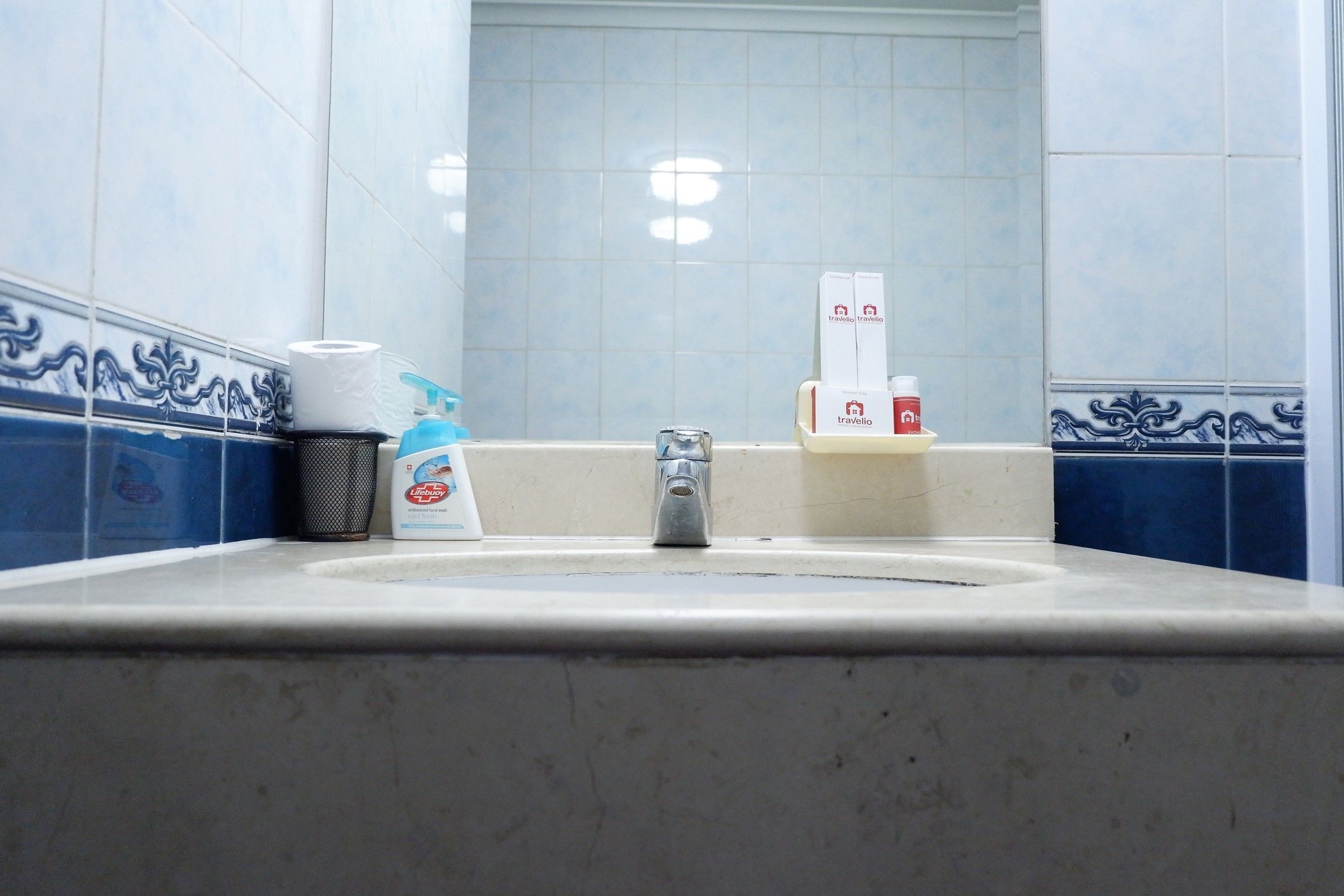 Ein Waschbecken mit Papierhandtuchspender, Seifenspender und einer Flasche Handseife.