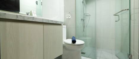 Ein modernes Badezimmer mit Toilette, Dusche und einer Glaskabine.