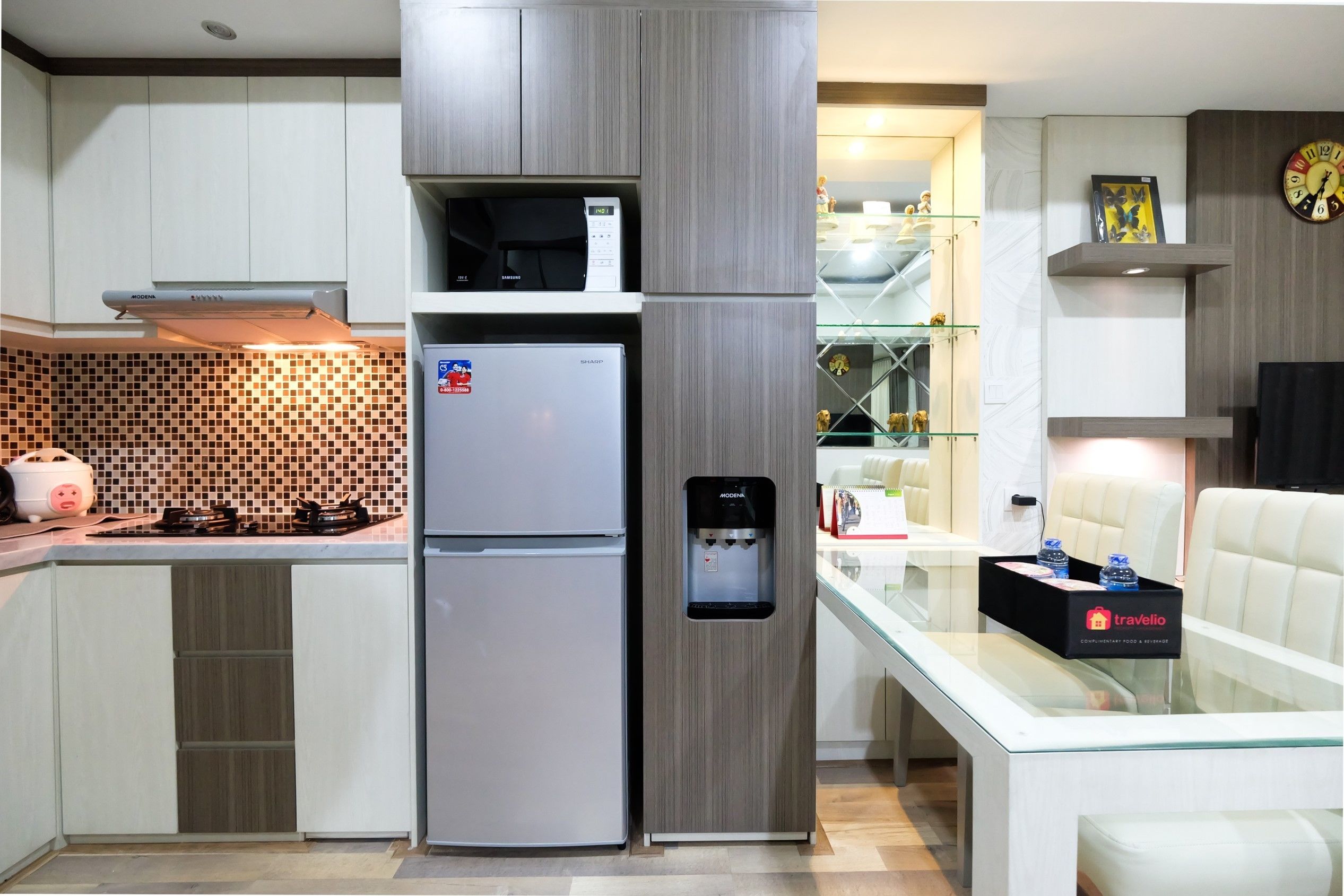 A modern kitchen with a built-in refrigerator, a water dispenser, and a gas stove.