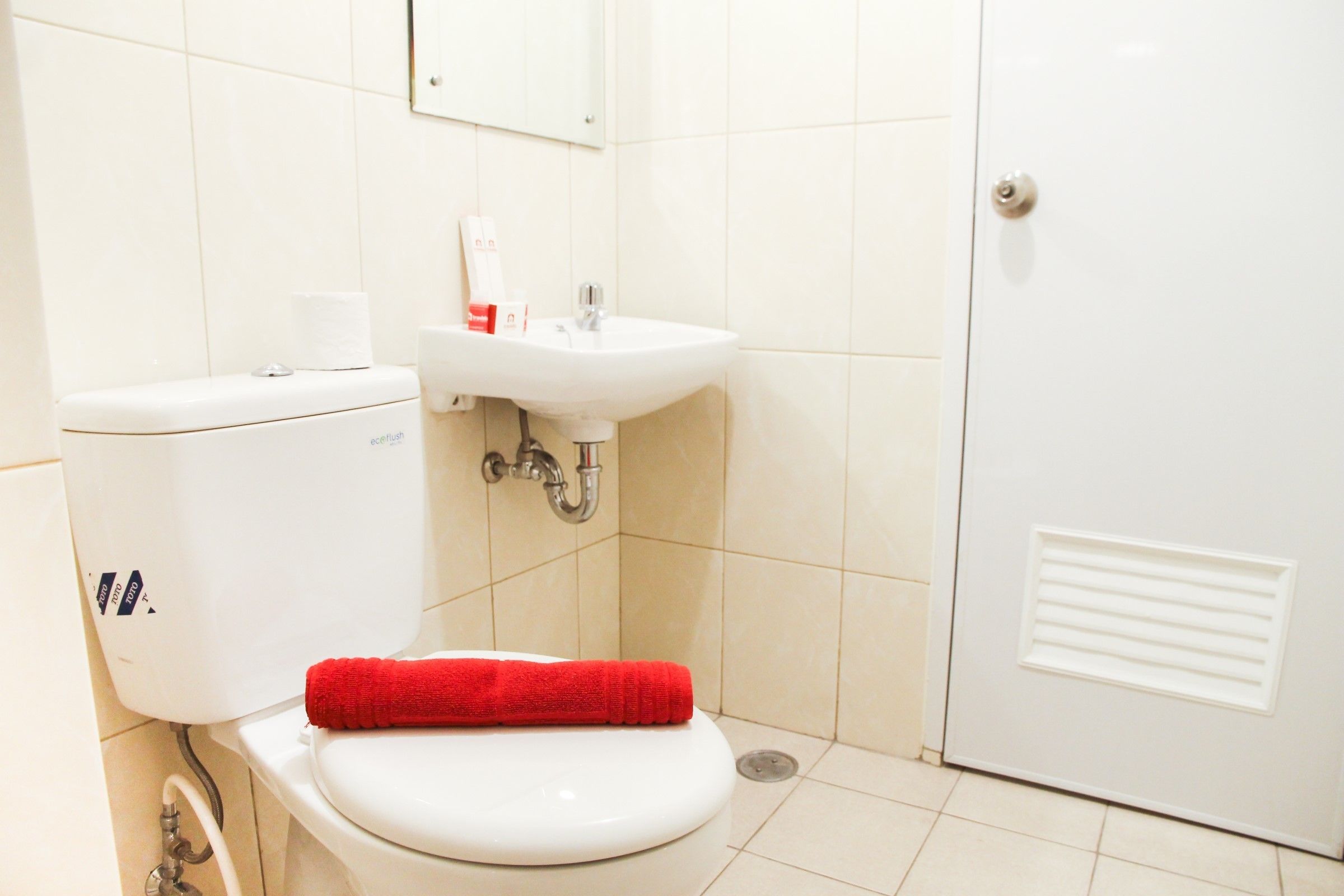 Ein Badezimmer mit Toilette, Waschbecken und einer Tür.