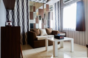 Un salon moderne avec un canapé, une table basse et un téléviseur.