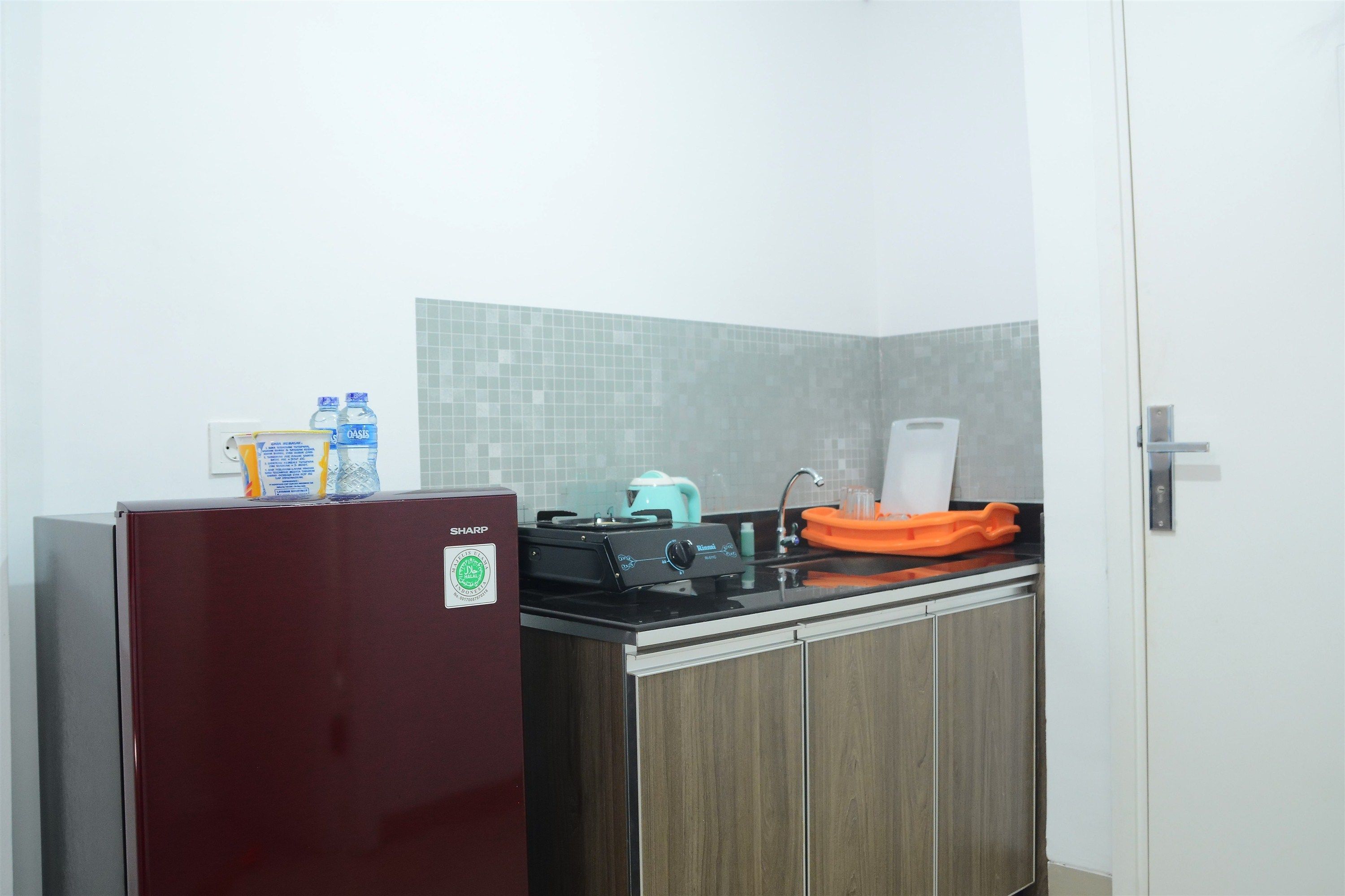 A compact kitchen with a refrigerator, a stove, and a sink.
