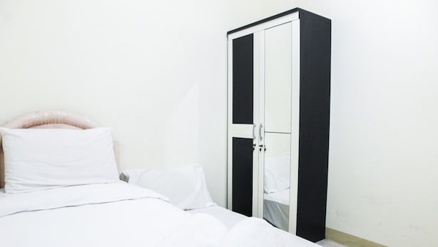 A single bed with white bedding and a neatly folded white towel. - 2BR Mediterania Palace Kemayoran Apartment (Jakarta)