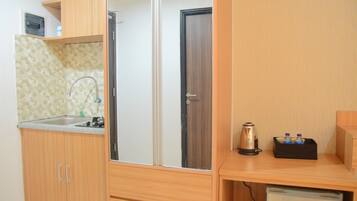 A compact kitchen with wooden cabinets, a sink, and a coffee maker on a small table.
