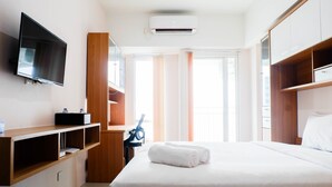 Une chambre d’hôtel équipée d’un lit, d’une télévision, d’un bureau et d’une armoire.