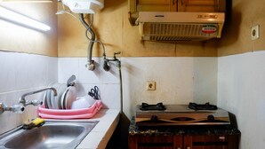Una cocina con un lavamanos, escurreplatos y estufa.