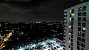A high-rise building with multiple balconies and a parking area below. - Bright Studio Apartment Serpong Greenview (South Tangerang)