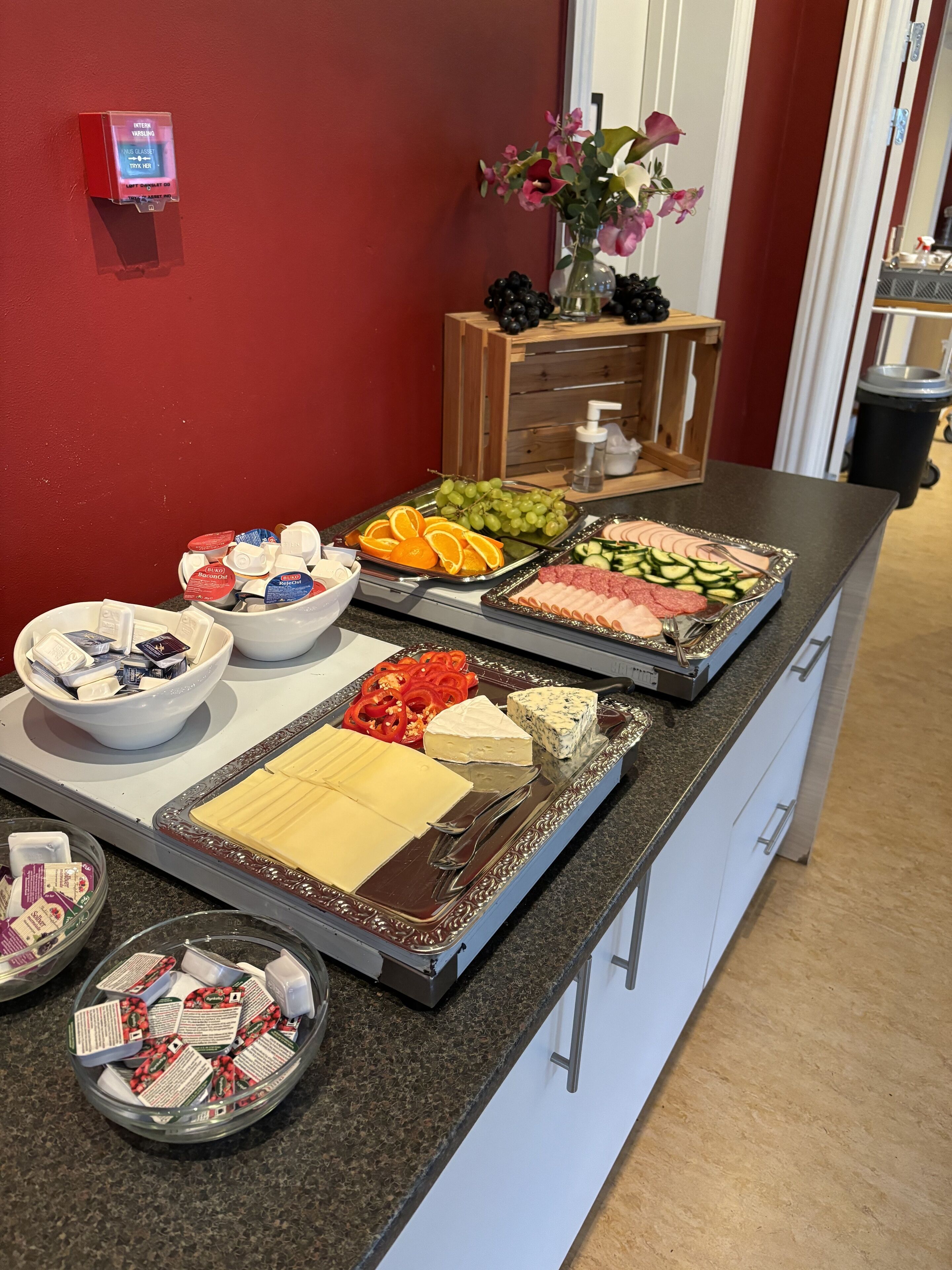 En buffet med forskellige spiser, herunder ost, kød, frugt og grøntsager.