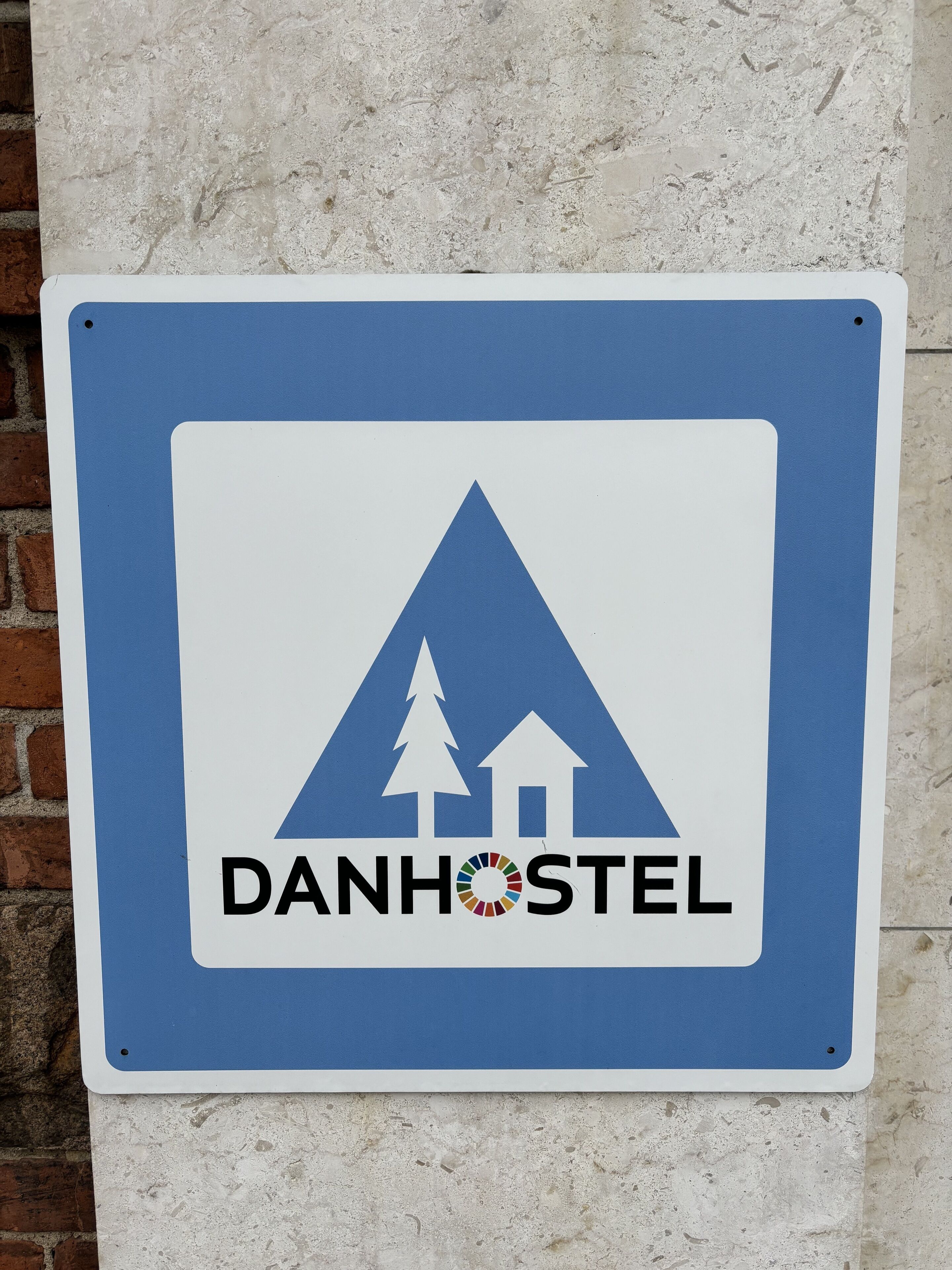 A sign with a mountain and houses symbol, and the text "DANHOSTEL".