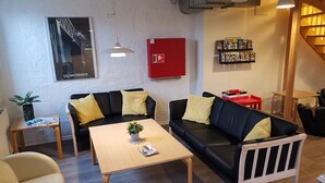 A modern living area with a sofa, coffee table, and a red cabinet.