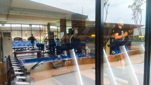 Une salle de sport équipée de divers appareils d’exercice, notamment des tapis de course et des appareils de musculation.
