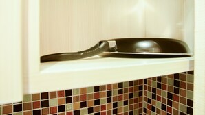 A kitchen with a white cabinet containing a black pan.
