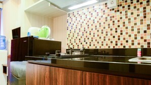 A modern kitchen with a wooden countertop, a sink, and a tiled backsplash.
