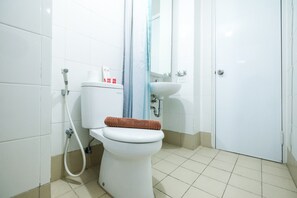 A bathroom with a toilet, a shower, and a sink. - Modern And Comfy 3BR Bassura City Apartment (Jakarta)