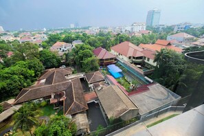 A residential area with multiple houses, some with red roofs, and a few with blue roofs. There are trees and greenery around the houses. - 2BR Cozy and Modern L'Avenue Apartment (Jakarta)