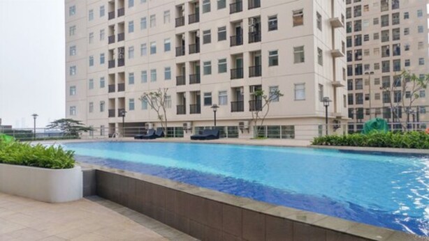 En moderne lejlighedsejendom med swimmingpool.