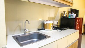 A kitchen with a stainless steel sink, a coffee maker, and a black appliance. - Pool View Studio Ara Residance Apartement Near Gading Serpong (Gading Serpong)