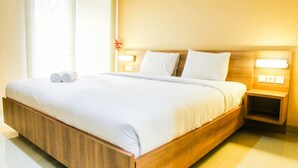 A modern hotel room with a large bed, wooden headboard, and bedside tables with lamps. - Pool View Studio Ara Residance Apartement Near Gading Serpong (Gading Serpong)