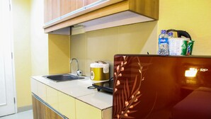 A compact kitchen with a sink, a coffee maker, a refrigerator, and a microwave. - Pool View Studio Ara Residance Apartement Near Gading Serpong (Gading Serpong)