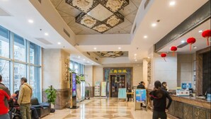 A hotel lobby with a check-in counter, seating area, and a patterned ceiling. - Shanghai Yueyi Apartment Hotel (Shanghai)