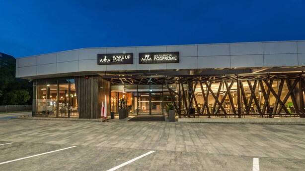 A modern building with signage for "Wake Up Coffee" and "Restauracja Podpromie."