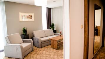 A modern living room with a sofa, armchair, and coffee table.