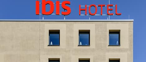 A hotel sign with the name "ibis HOTEL" in red letters.