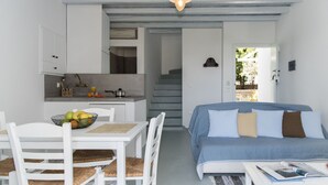 Un espacio habitable compacto con comedor, kitchenette y cama con vistas.