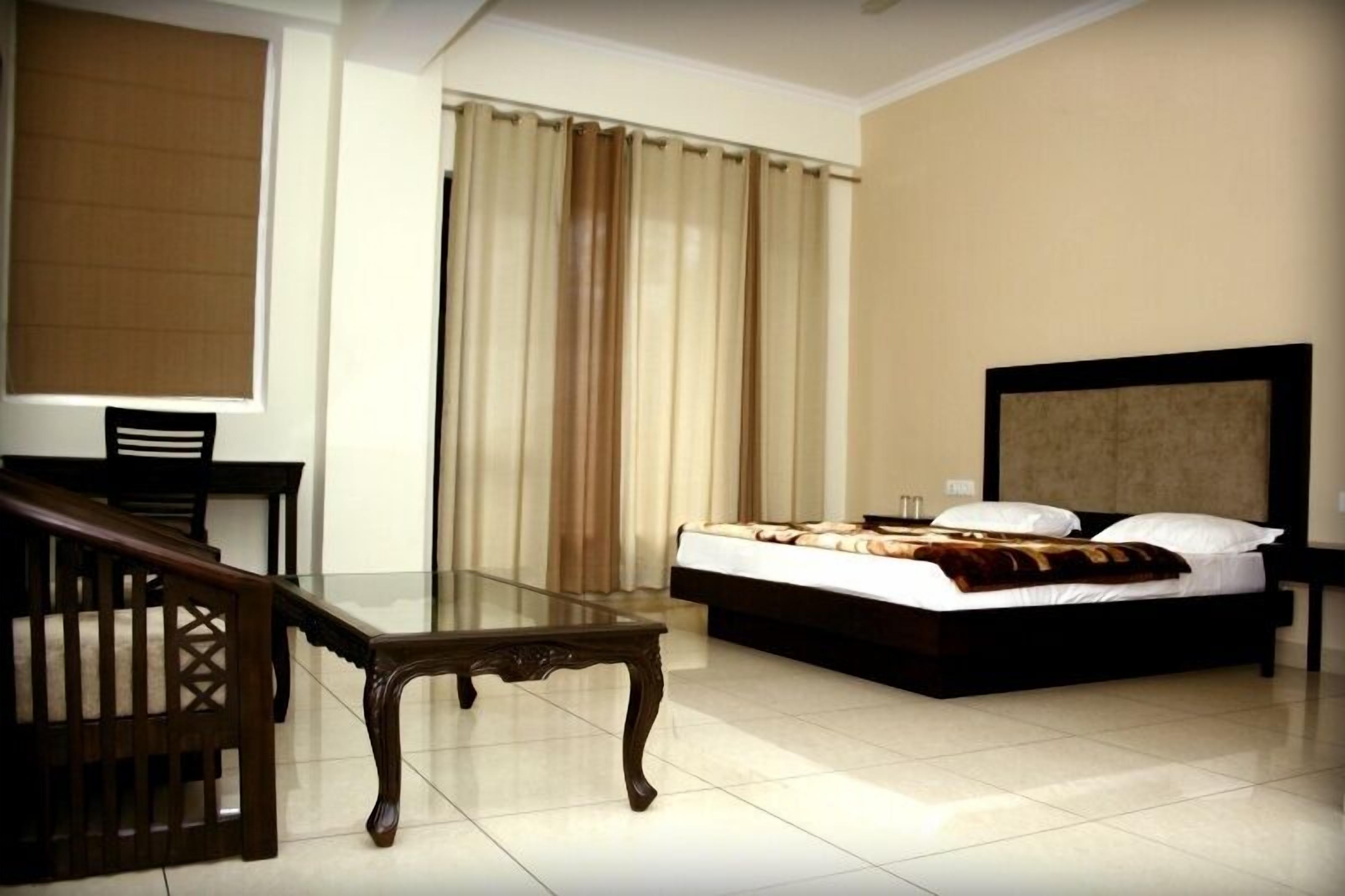 Una habitación de hotel con una cama, un escritorio y una silla.