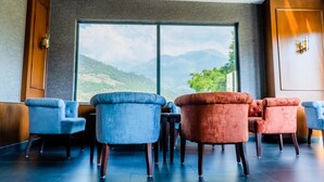 A seating area with a view of mountains through large windows.