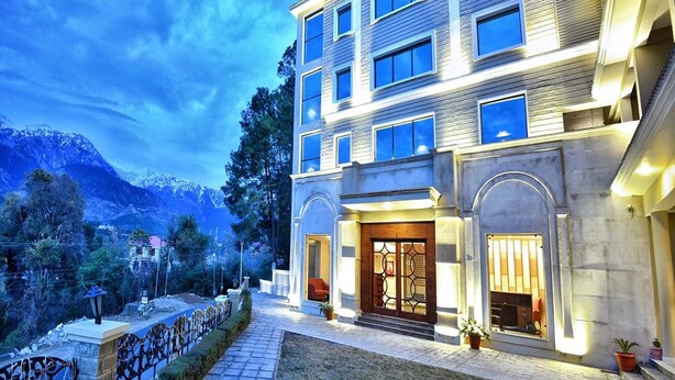 A multi-story hotel with a modern facade, large windows, and a well-lit entrance.