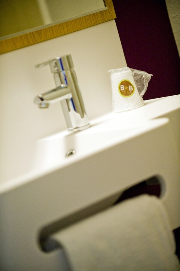 A bathroom sink with a towel rack and a soap dispenser.