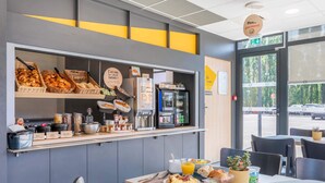 Un buffet de petit-déjeuner proposant une variété d’aliments et une machine à café.
