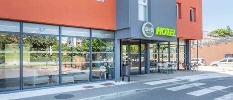 Un hotel d'estil casa amb un disseny modern, amb grans finestres de vidre i una zona de seients a l'exterior.