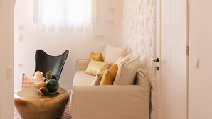 A cozy living room with a sofa, a round coffee table, and a patterned floor. - AmazeU Naxos (Naxos)
