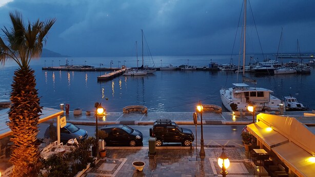 A marina with boats docked, a parking area, and a palm tree. - AmazeU Naxos (Naxos)
