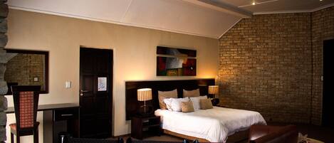 Une chambre d’hôtel comprenant un lit, des tables de chevet, un bureau et une chaise.