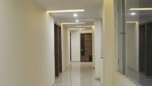 A long, narrow hallway with a shiny tiled floor and recessed lighting. - The Darien Resort (Kaladhungi)